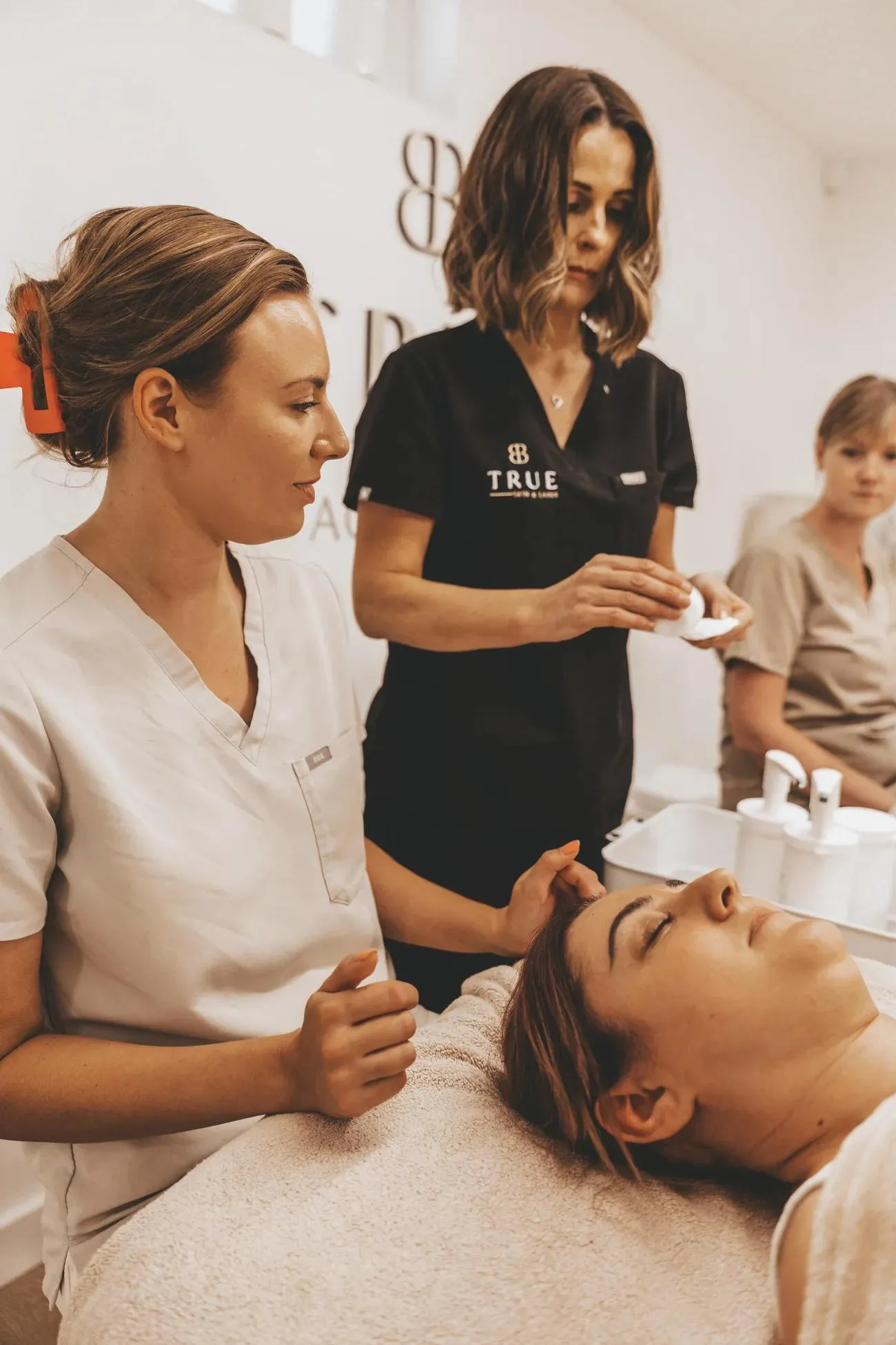 Sarah teaching a student during a facial treatment in the academy clinic