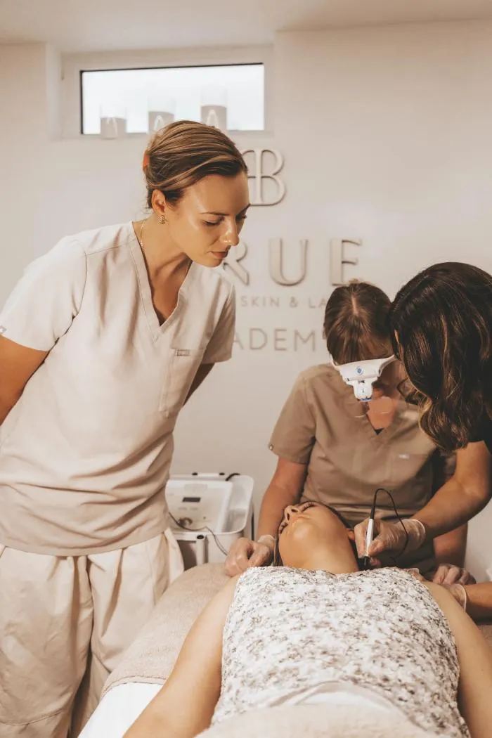An advanced cosmetic procedure being carried out under a magnifying lamp