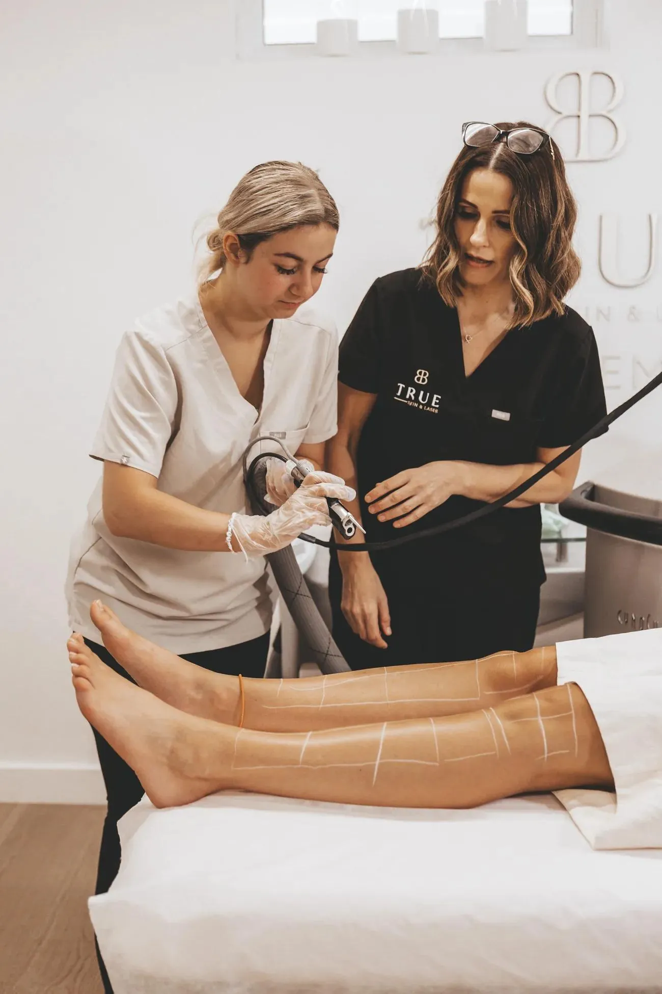 Sarah watching closely as a student operates the laser on a live model