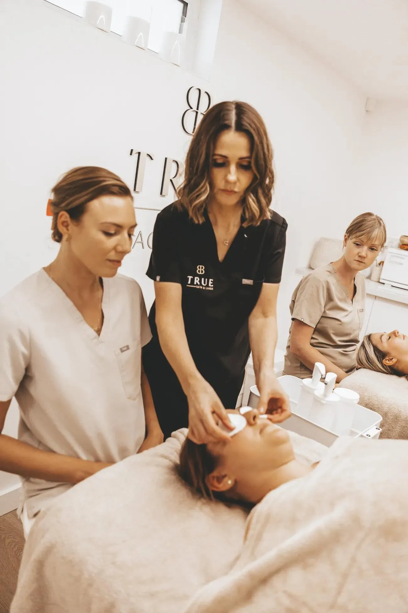 Sarah demonstrating a cleanse on a model while a student watches closely