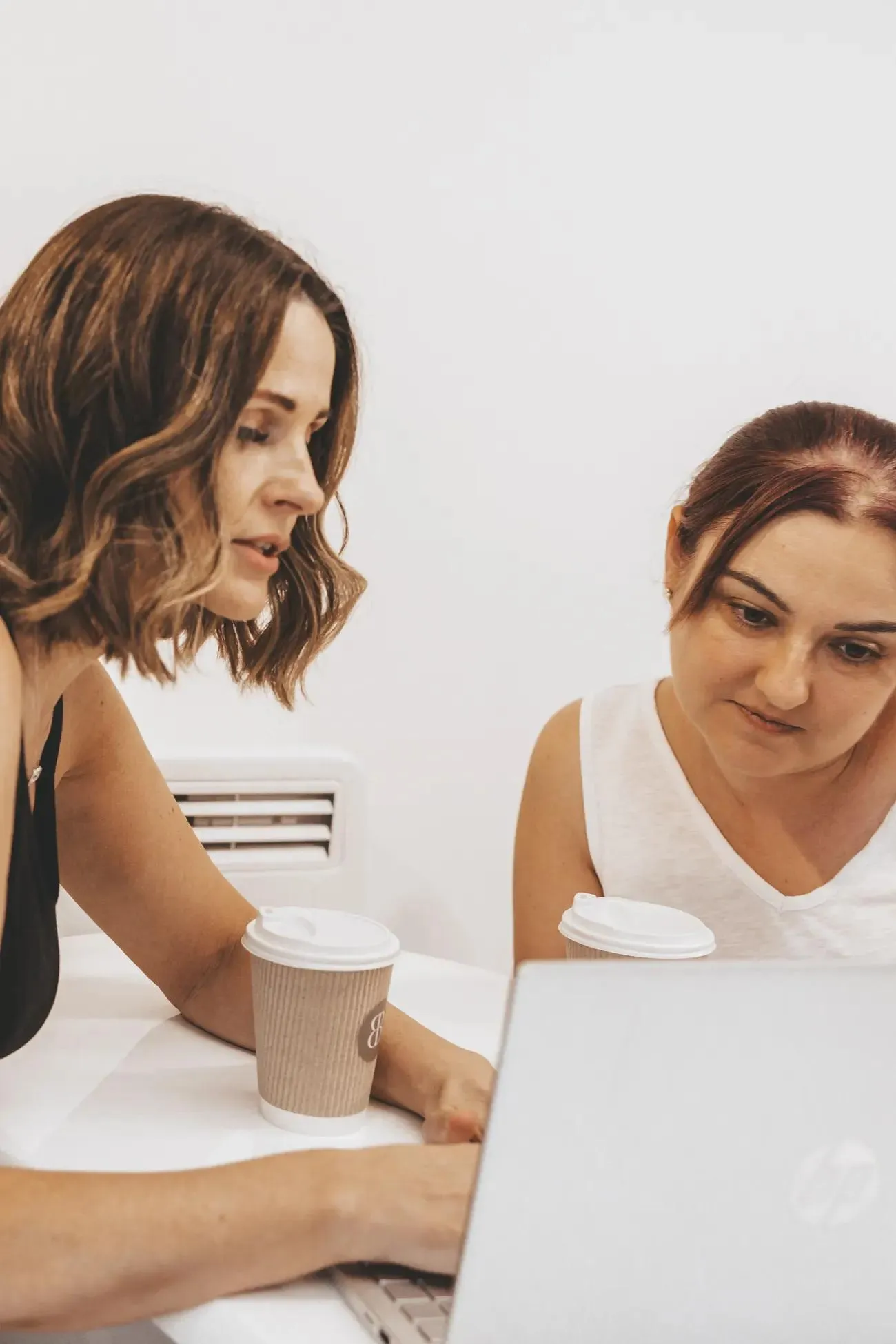 Sarah working through course theory at a laptop with a student