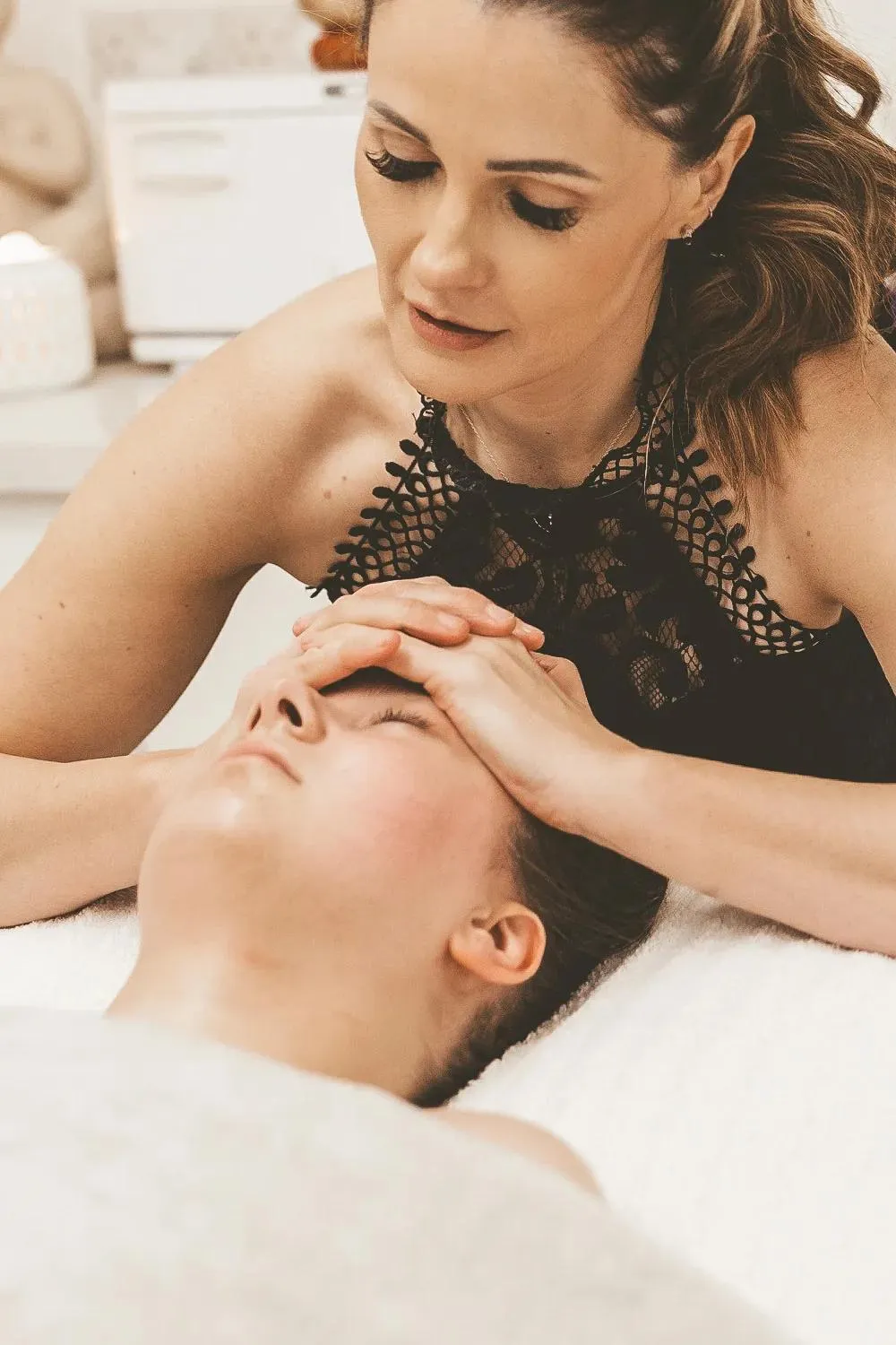 Sarah's hands resting along a client's forehead partway through the massage sequence