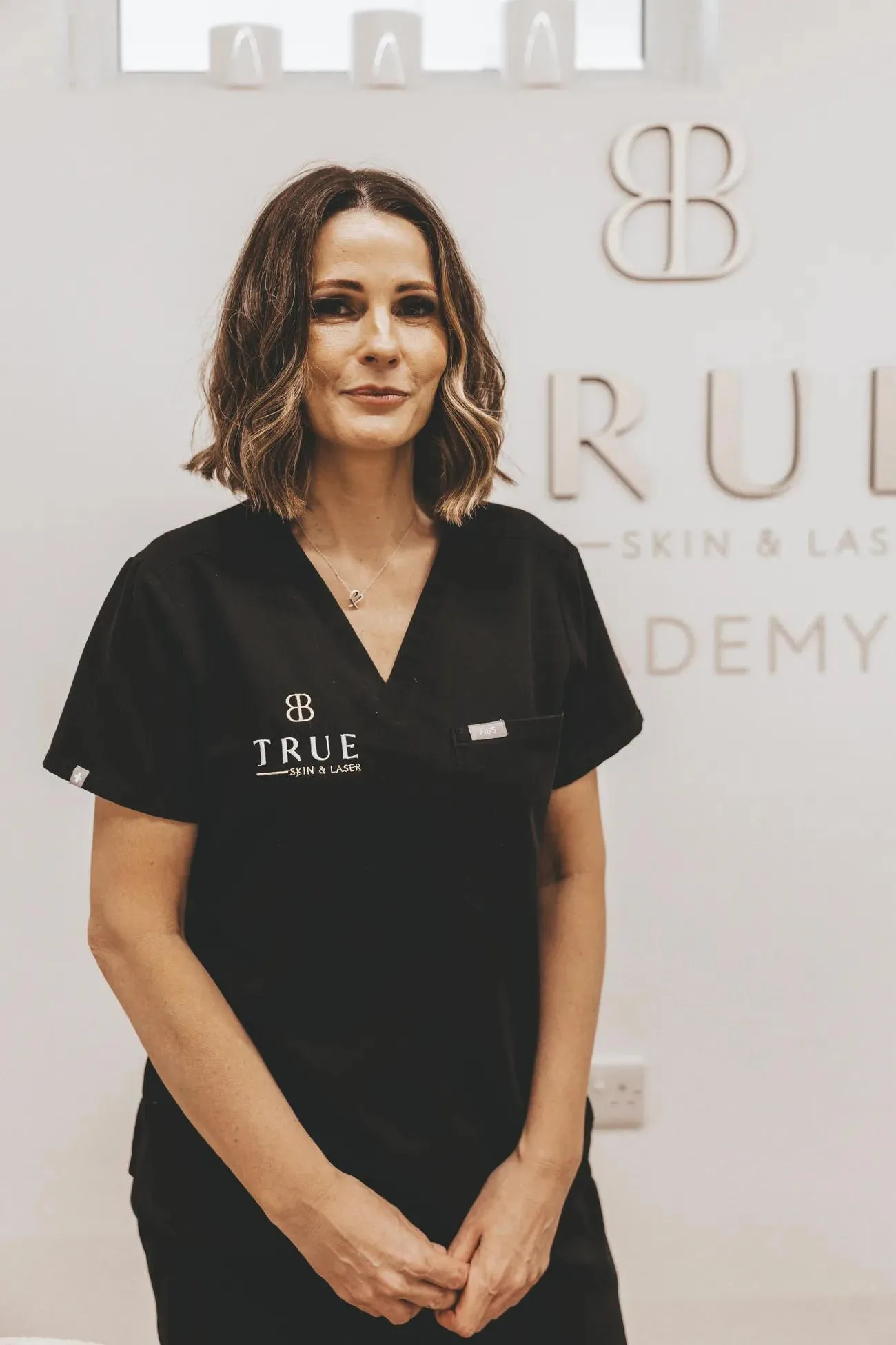 Sarah, founder of True Skin and Laser Academy, in front of the academy signage