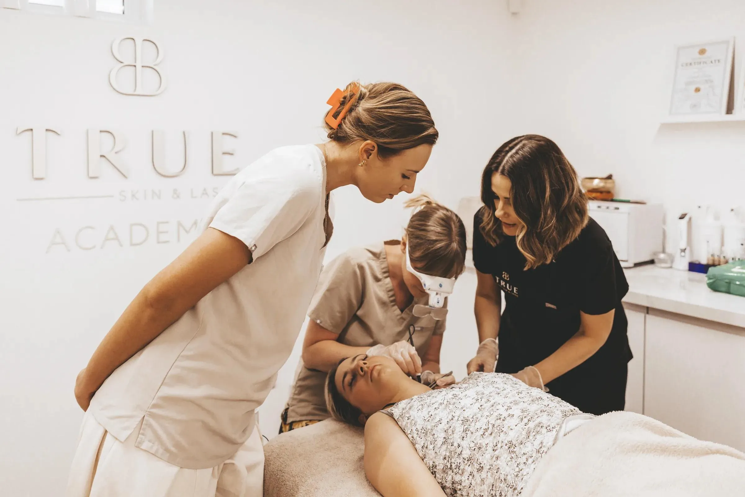 Sarah supervising two students during an advanced electrolysis treatment in the academy clinic