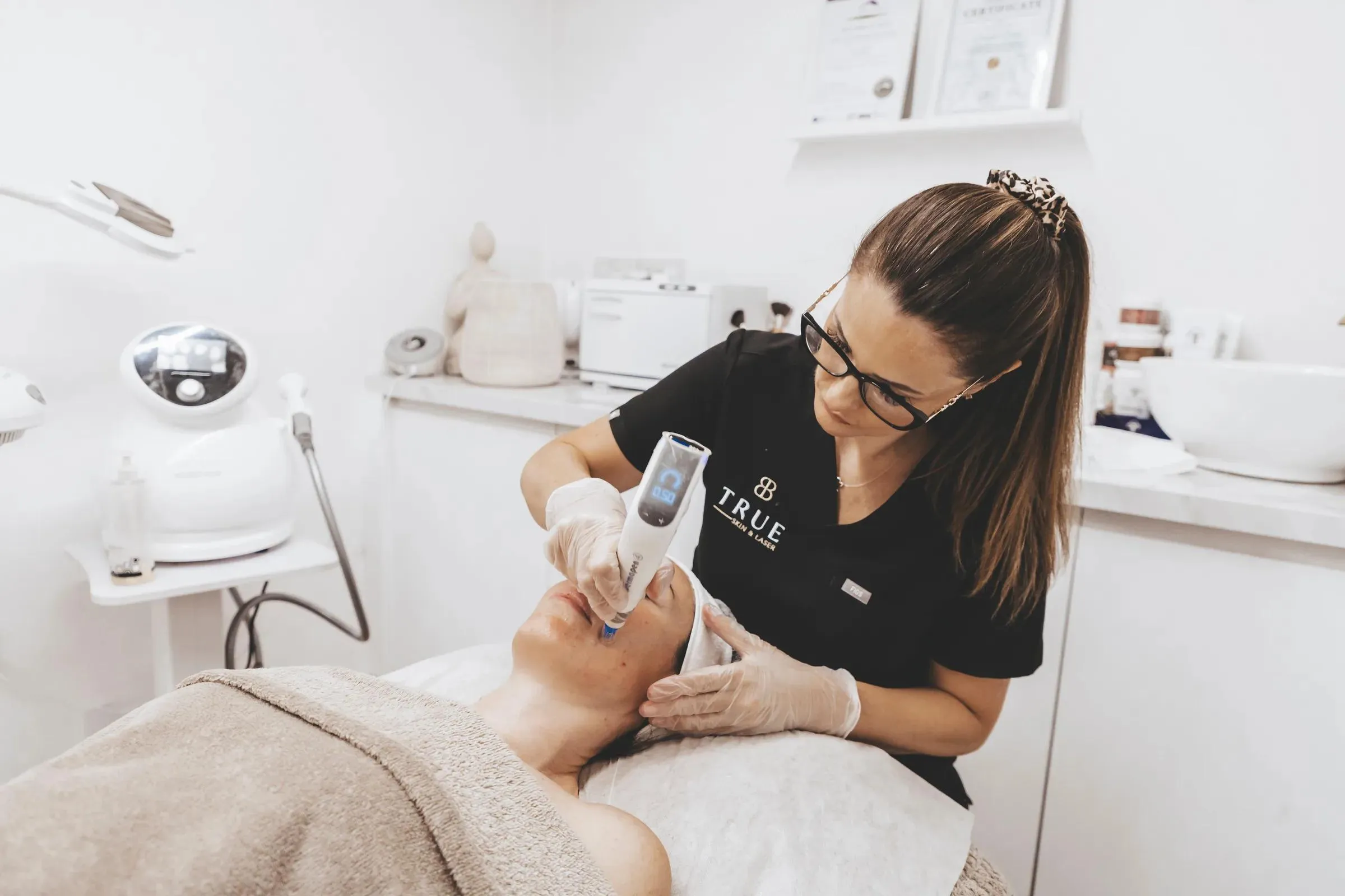 Sarah treating a client with a microneedling pen in the academy clinic