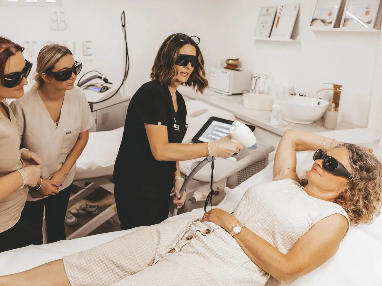 Students practising laser treatment on a model during a training day