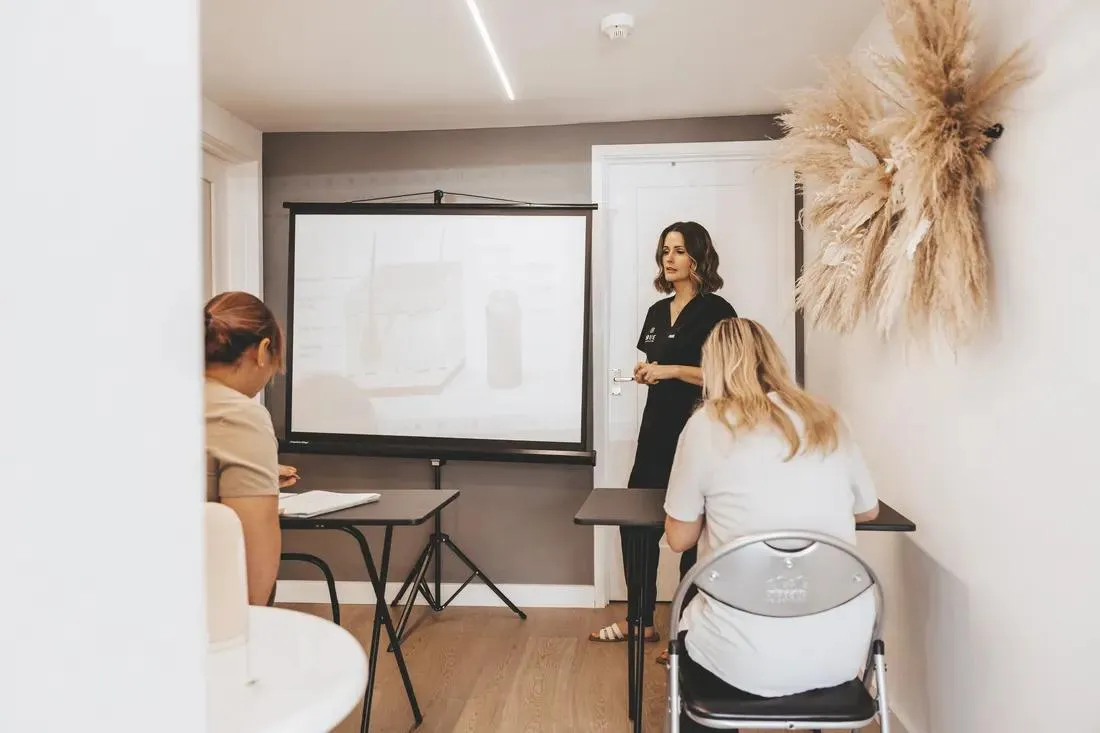Sarah teaching a theory session to two students in the academy classroom