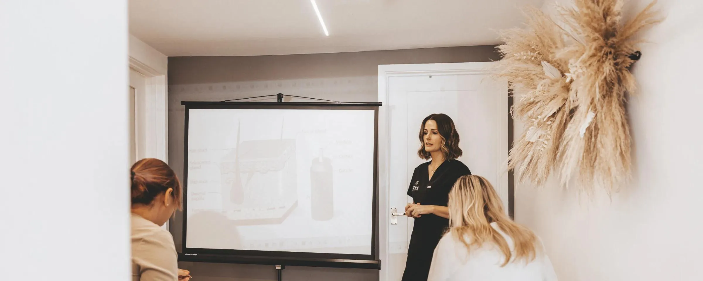 Sarah teaching a session on skin structure to a student at the academy