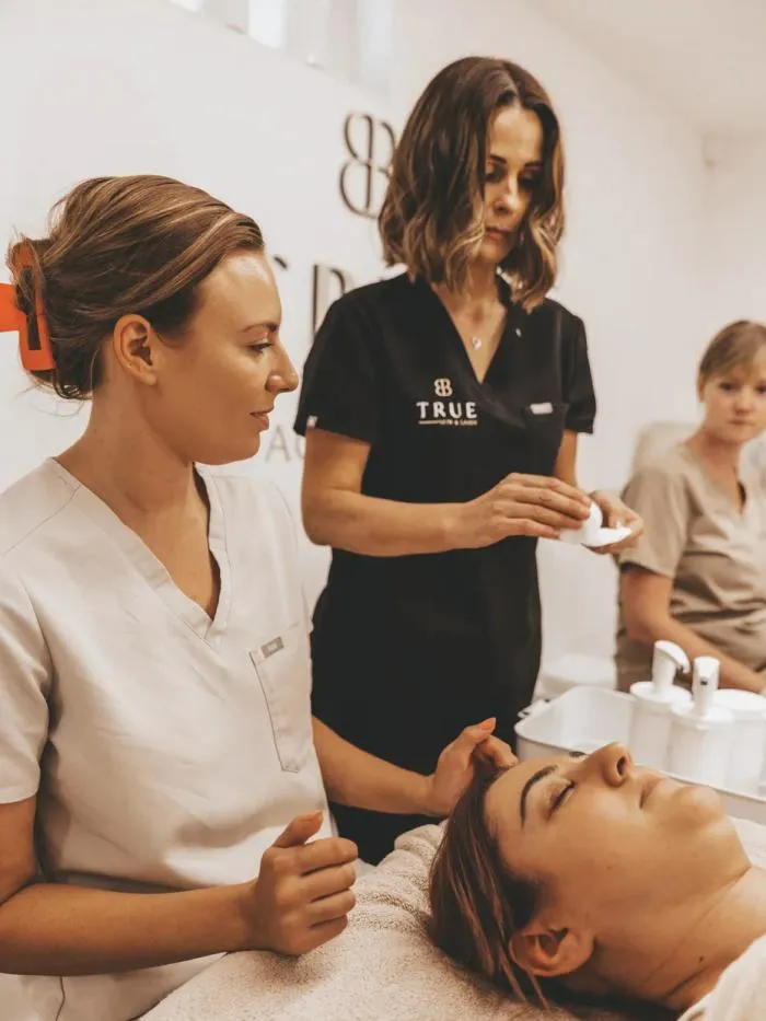 Sarah supervising a student carrying out a facial treatment during training at the academy