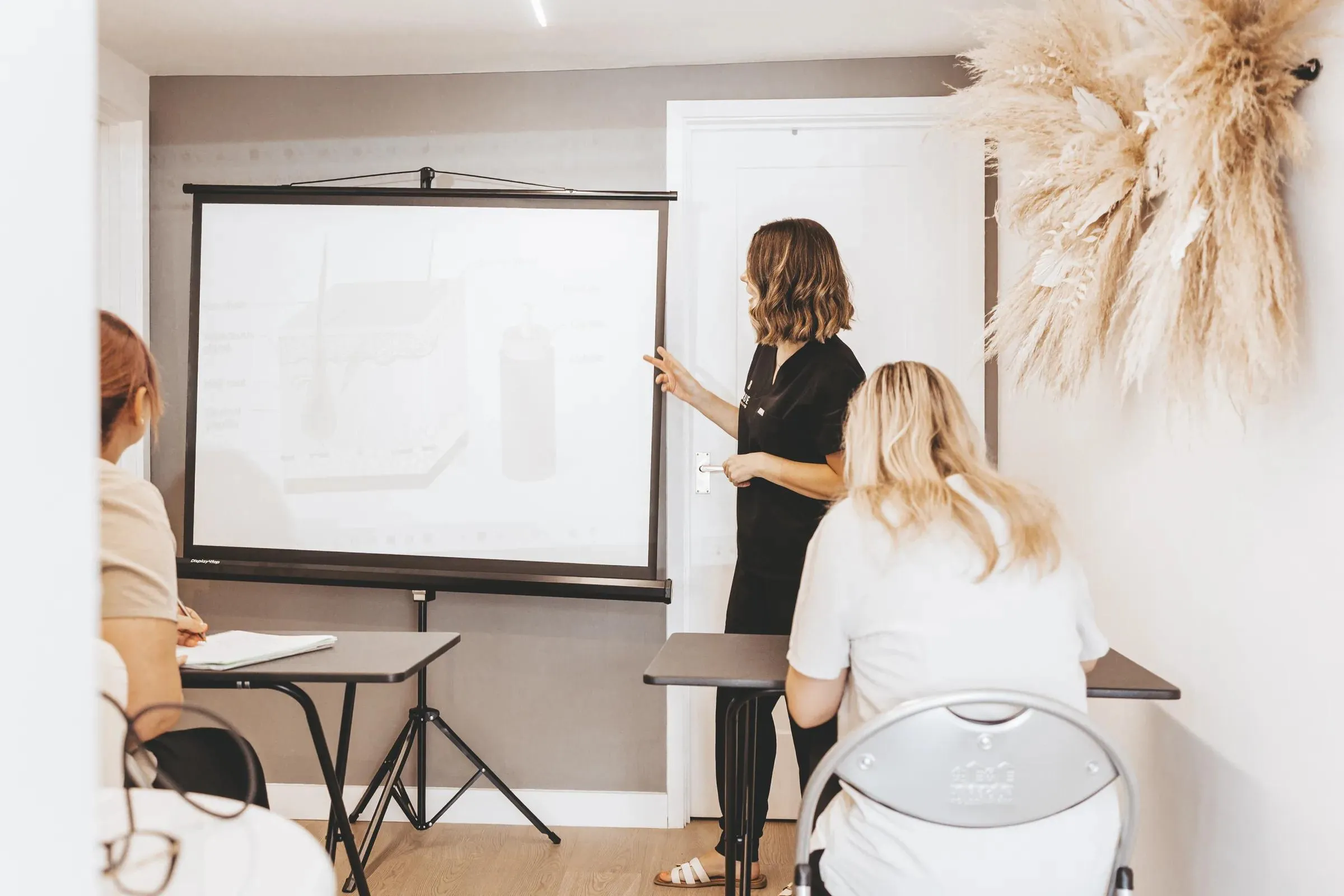 Sarah teaching a skin structure session to two students in the academy training room